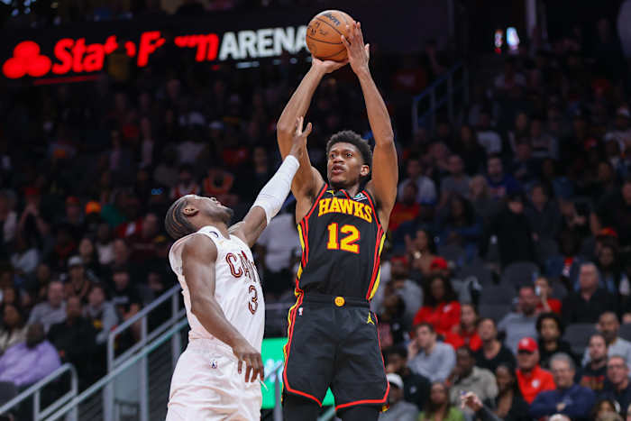 Mar 28, 2023; Atlanta, Georgia, USA; Atlanta Hawks forward De'Andre Hunter (12) shoots over Cleveland Cavaliers guard Caris LeVert (3) in the second half at State Farm Arena. Mandatory Credit: Brett Davis-USA TODAY Sports